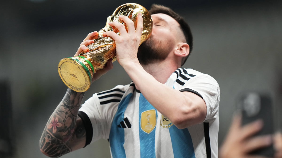 Argentina's forward #10 Lionel Messi celebrates holding the World Cup Trophy at the end of the Qatar 2022 World Cup final football match between Argentina and France (AFP)